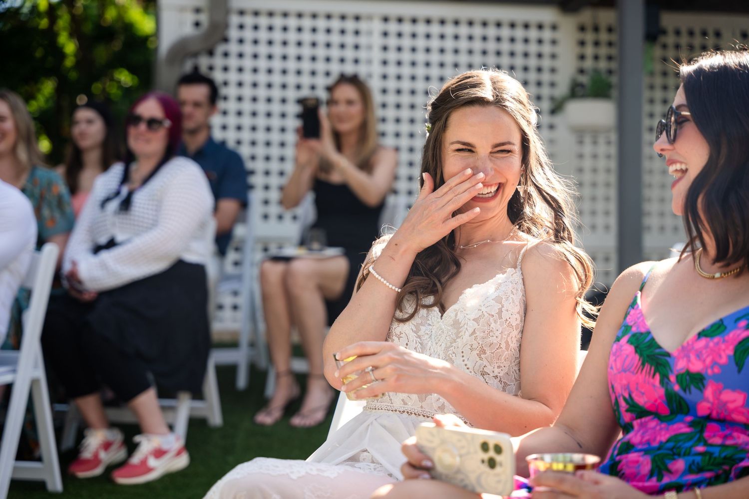 Emotional wedding guest reacts during outdoor ceremony.