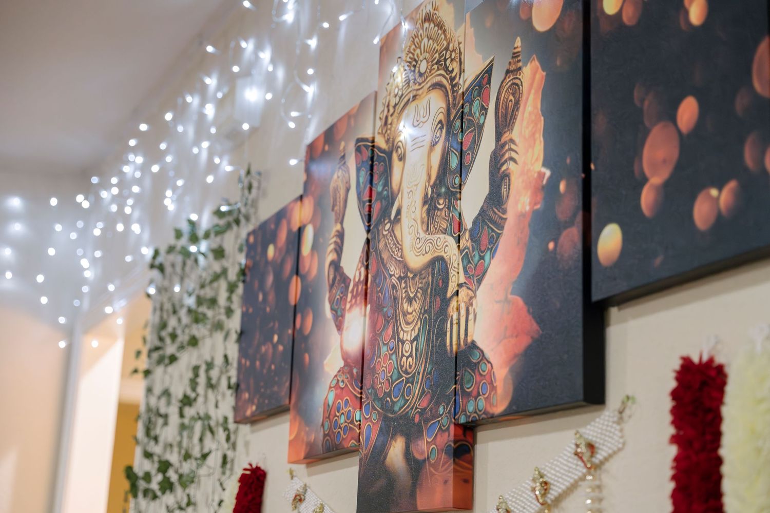 String lights illuminate wall-mounted artwork featuring whimsical designs and patterns.
