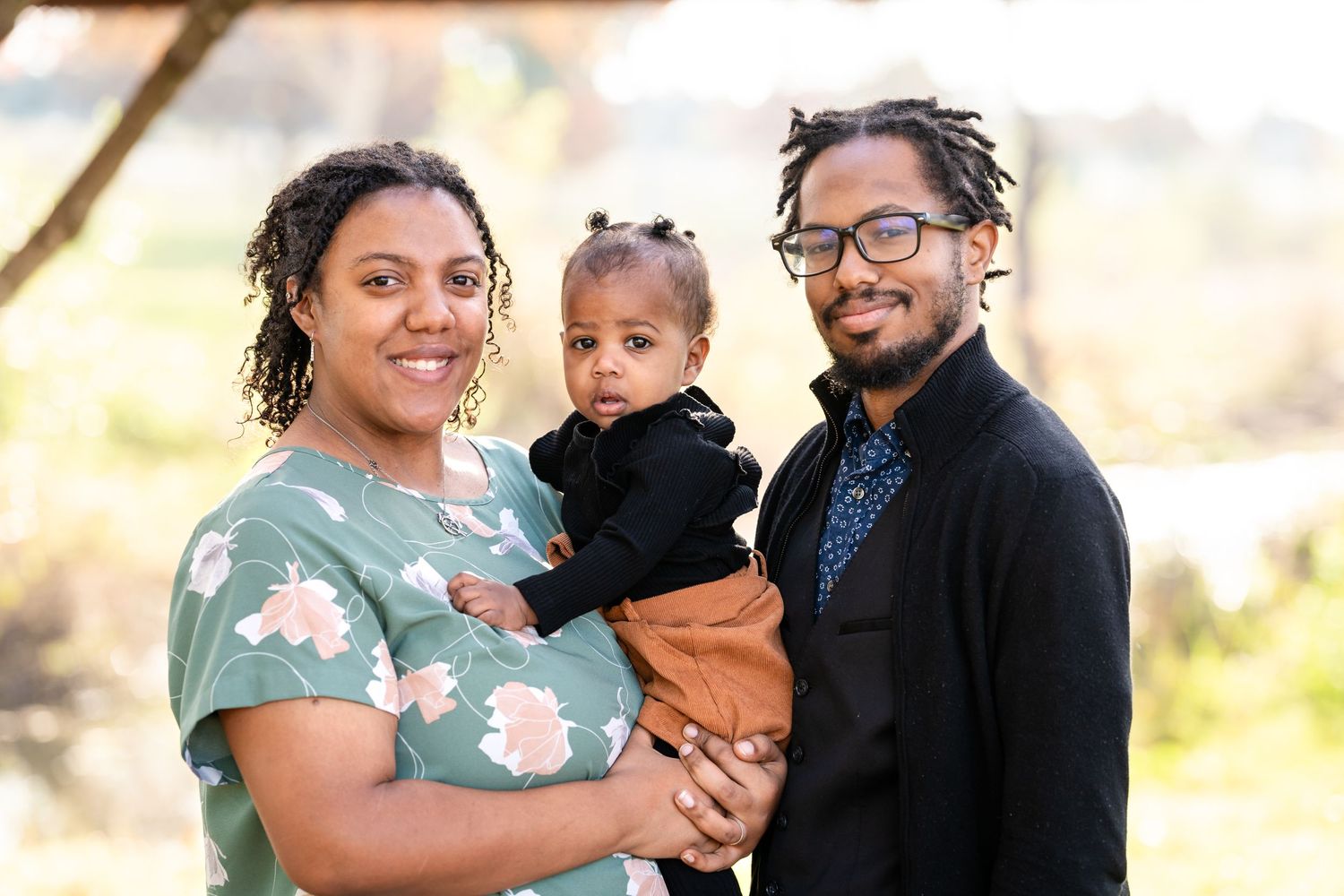 A happy family portrait taken outdoors with beautiful natural lighting.