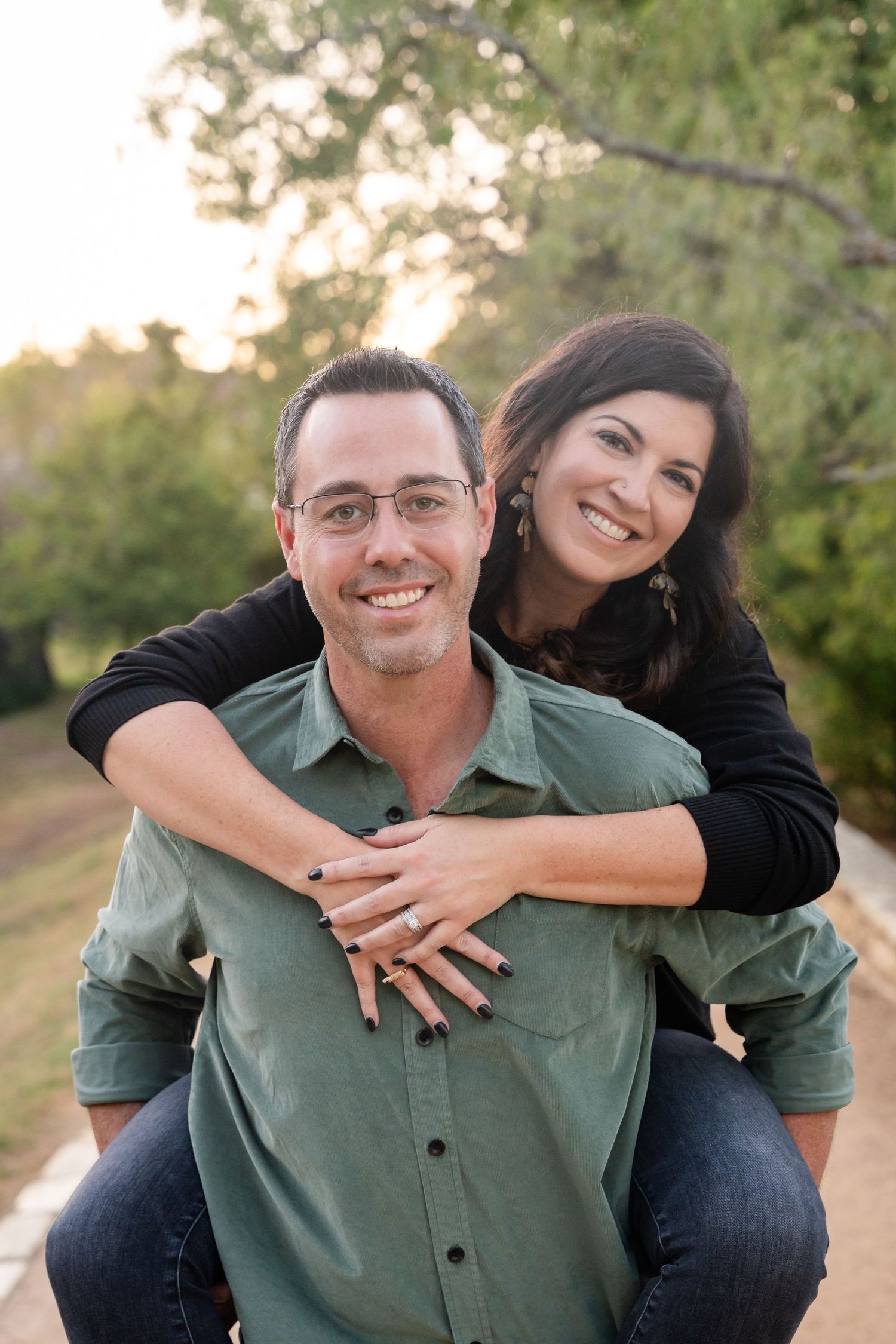 A playful piggyback portrait of a couple outdoors during golden hour.