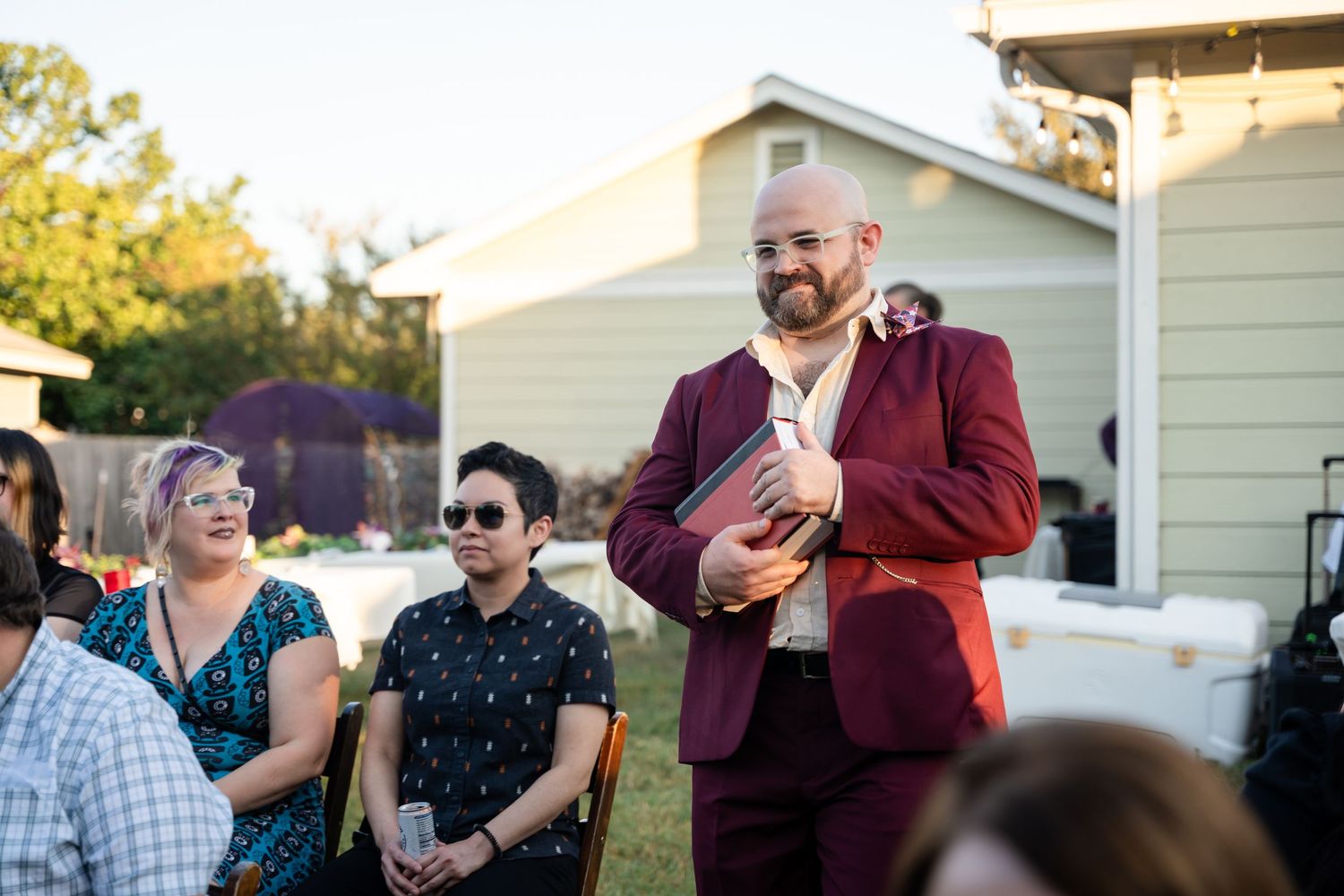 A speaker addresses guests at an outdoor celebration.