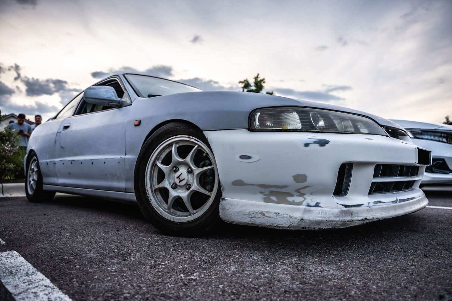 Modified white Nissan Skyline GT-R with custom wheels photographed at low angle.