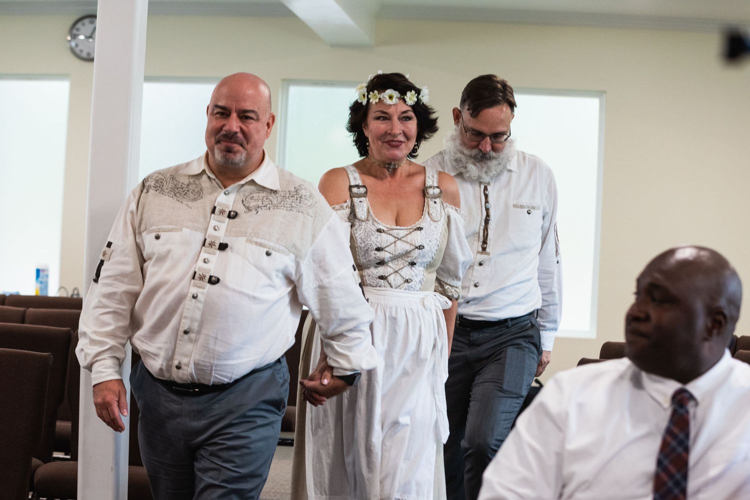 Wedding ceremony participants walk together in a festive traditional German-style celebration.
