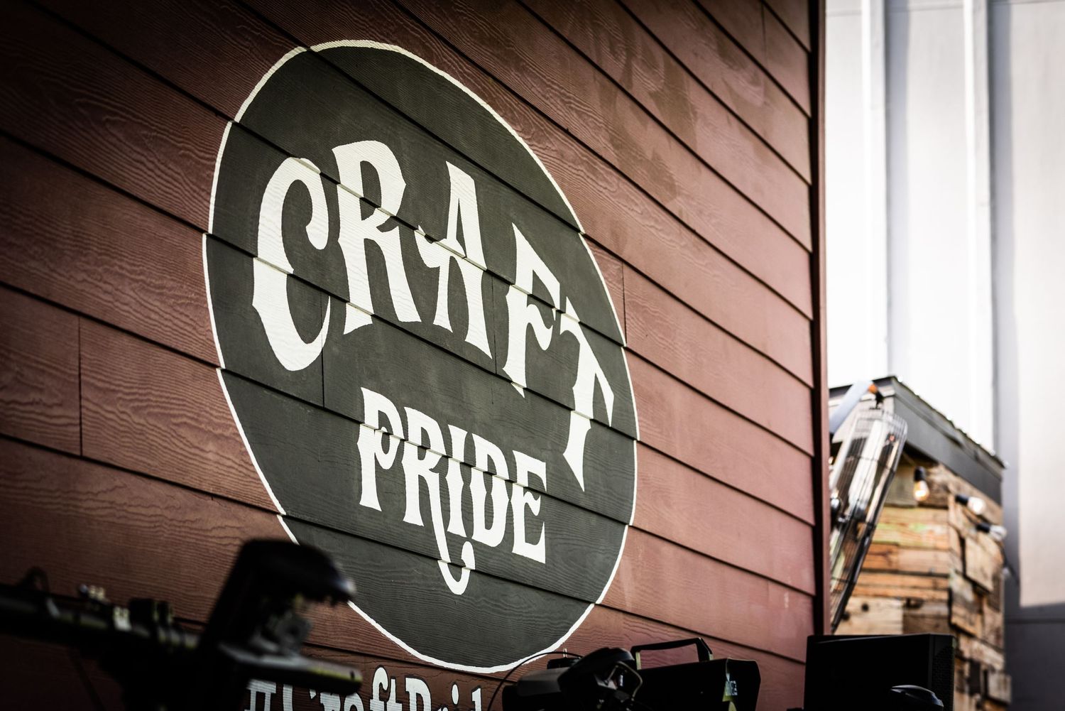 Craft Pride circular sign mounted on wooden wall exterior.