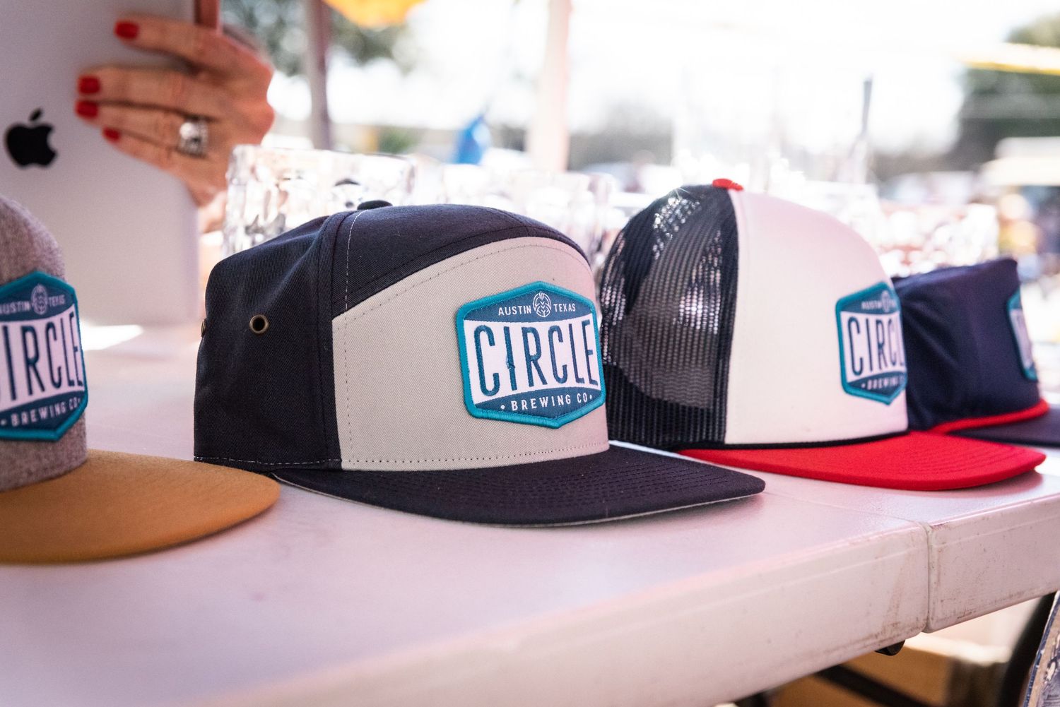 Circle Brewing Company branded snapback hats displayed on retail counter.
