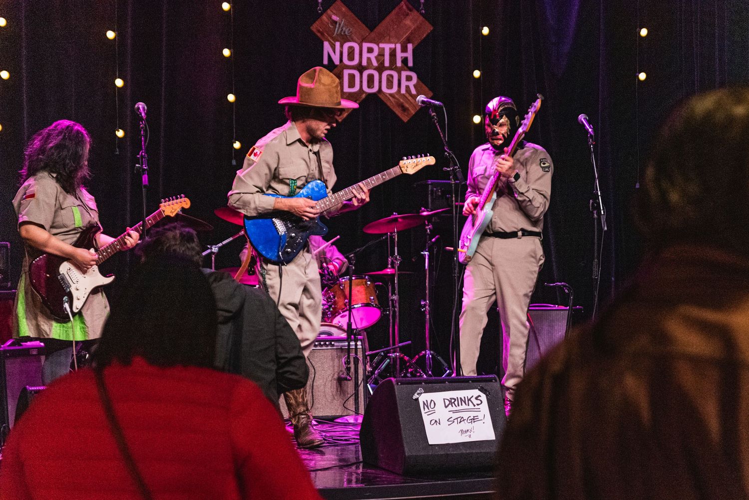 Band performing live on stage at North Door venue with multiple guitarists and drum kit.