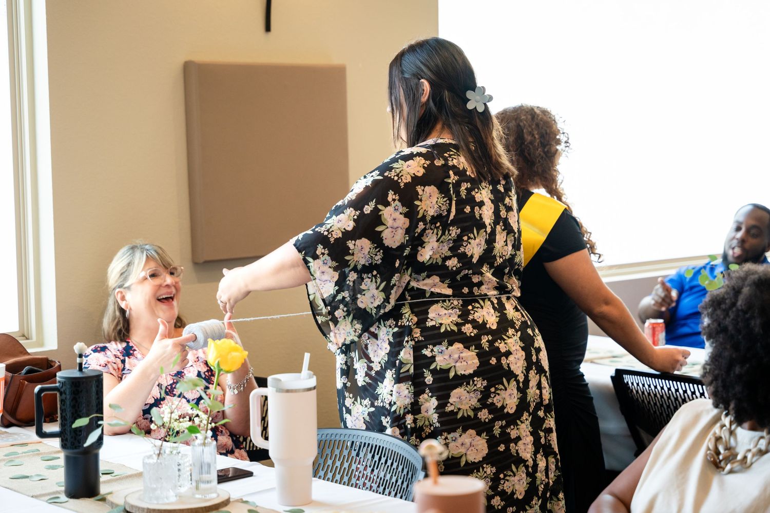 Guests enjoying a social gathering around tables decorated for a celebration.