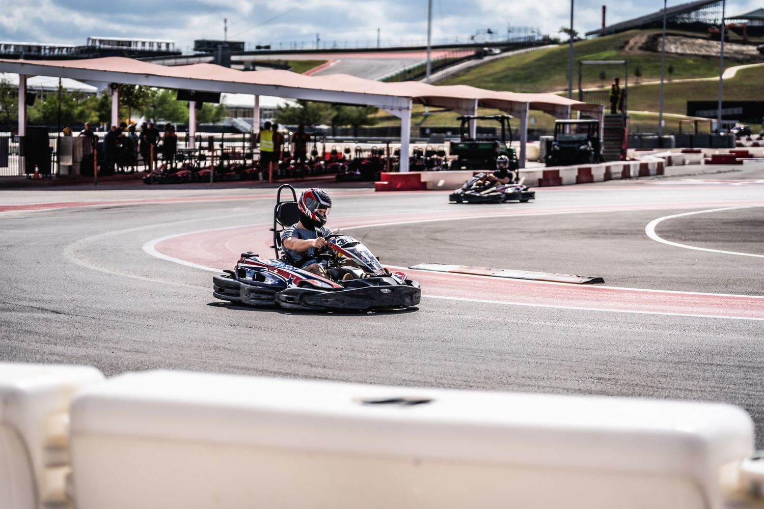 Go-kart speeding through a curve on professional karting circuit.