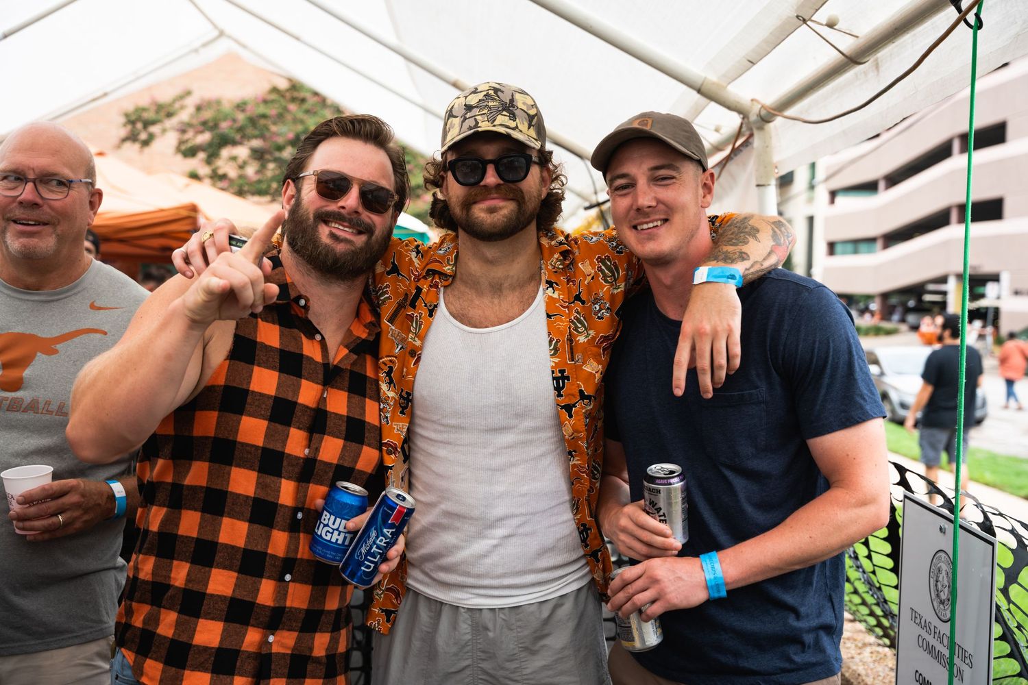 Group of friends enjoying drinks at an outdoor party wearing casual attire.