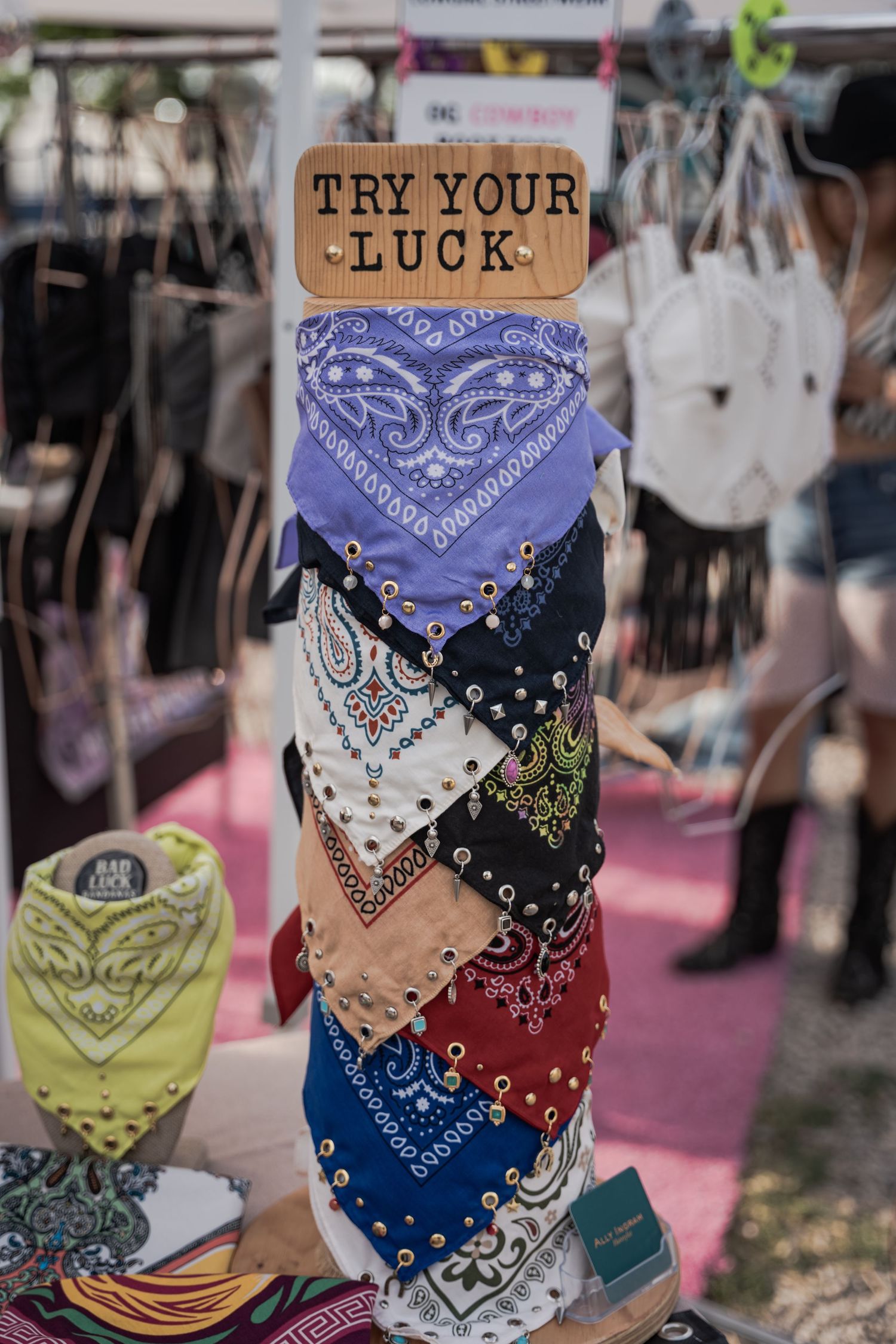 Colorful bandanas with studs displayed on a post under a 