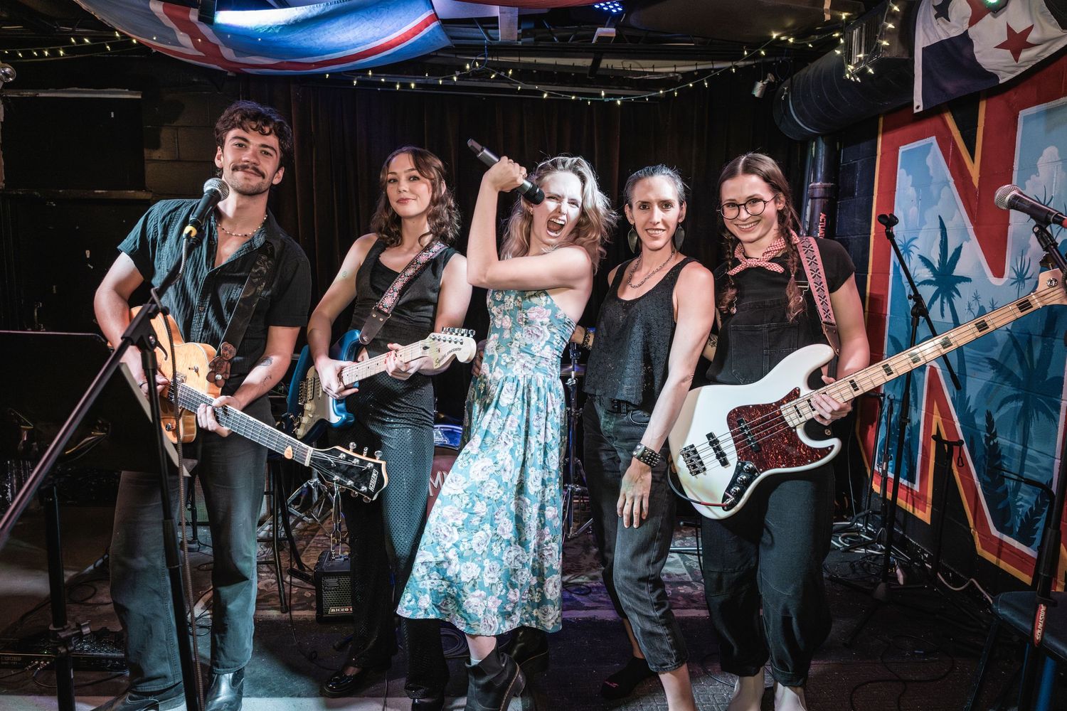Bluegrass band performs energetically on stage with banjo, guitar and upright bass players in a live music venue.