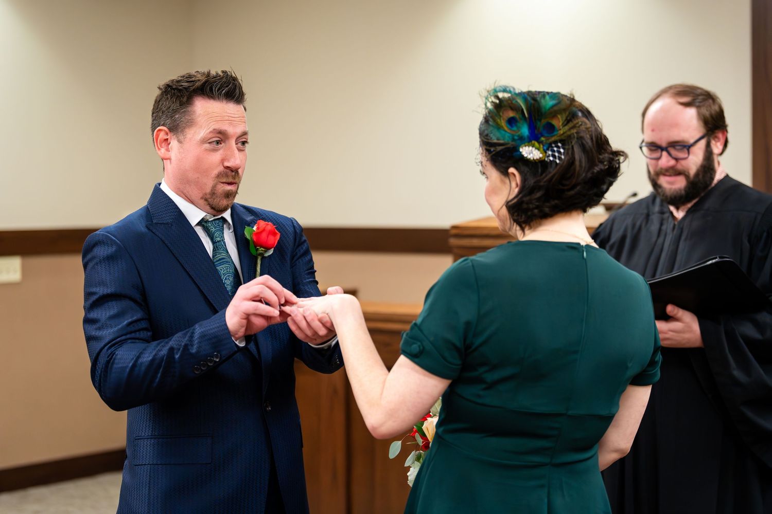 A couple exchanges rings during their civil ceremony as the judge officiates.