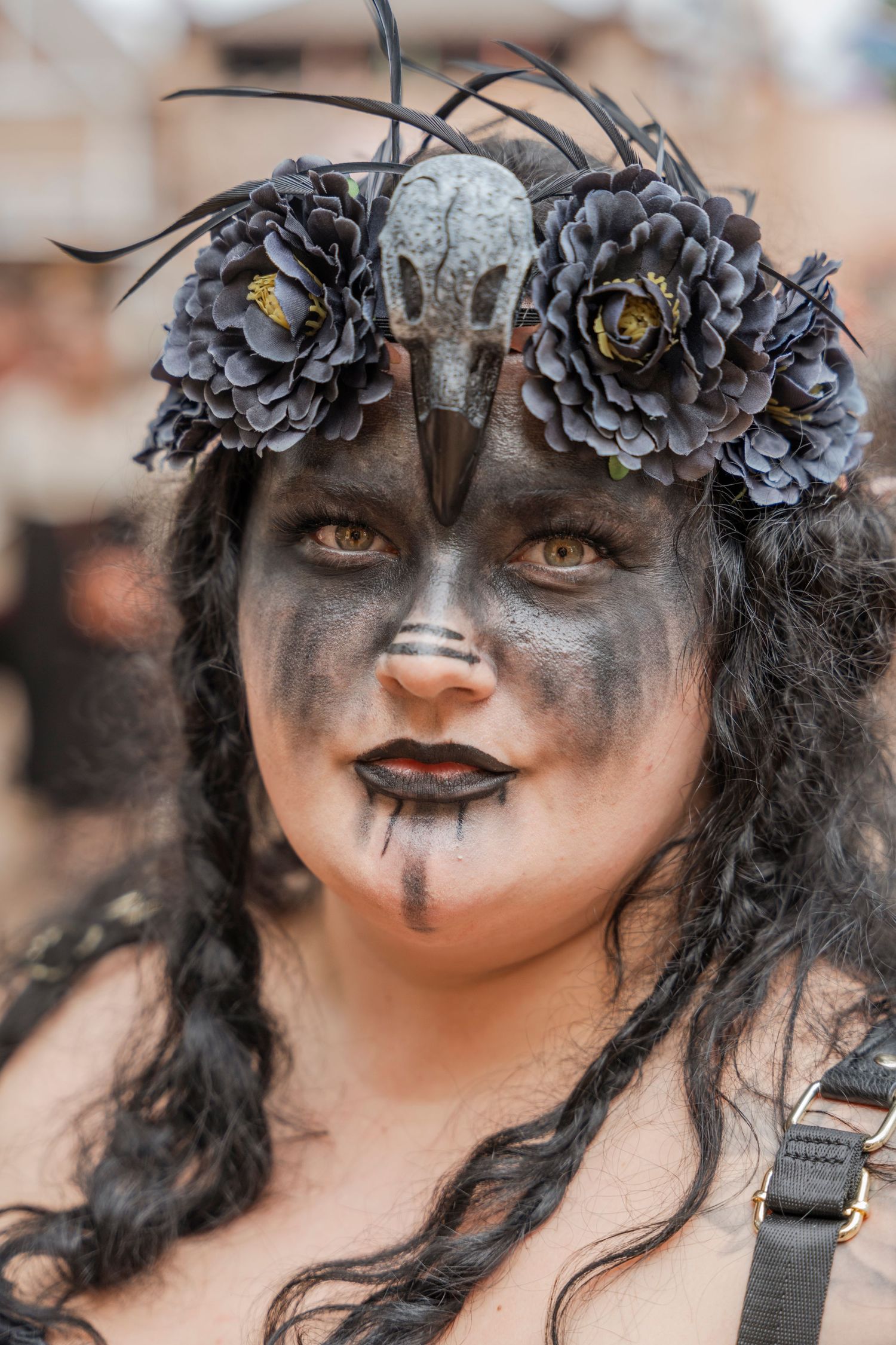 Gothic costume featuring dark makeup, grey flowers, and dramatic black face paint.