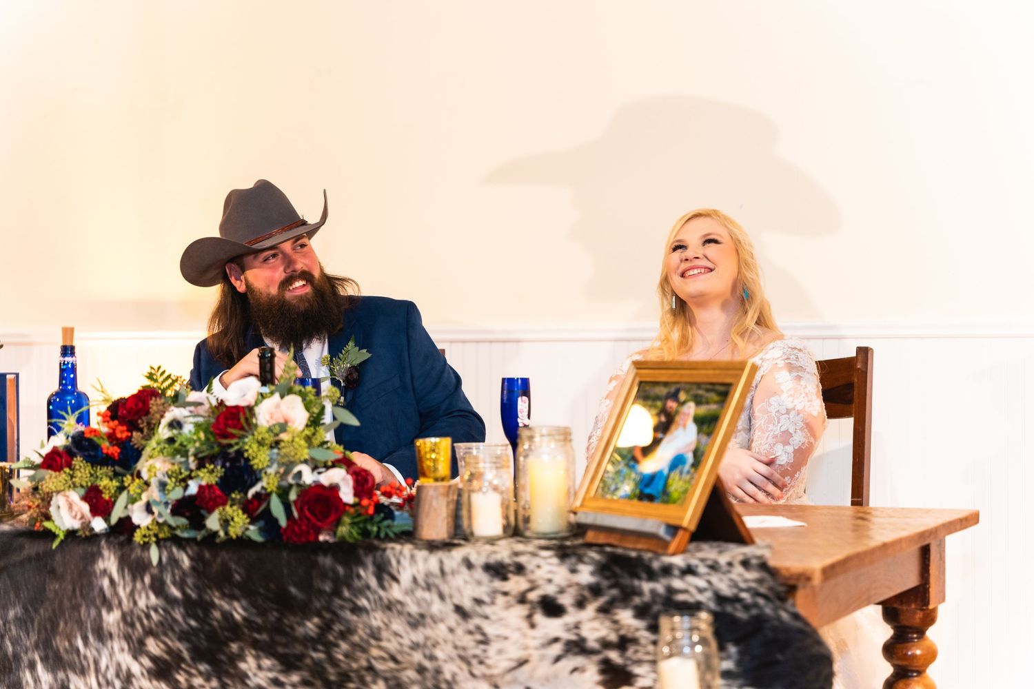 Western-themed wedding reception with rustic table decorations and floral arrangements.