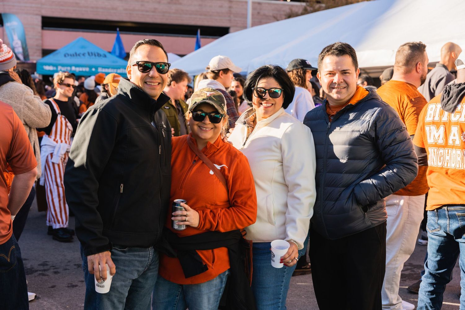 Friends gathered together at an outdoor sporting event wearing team colors.