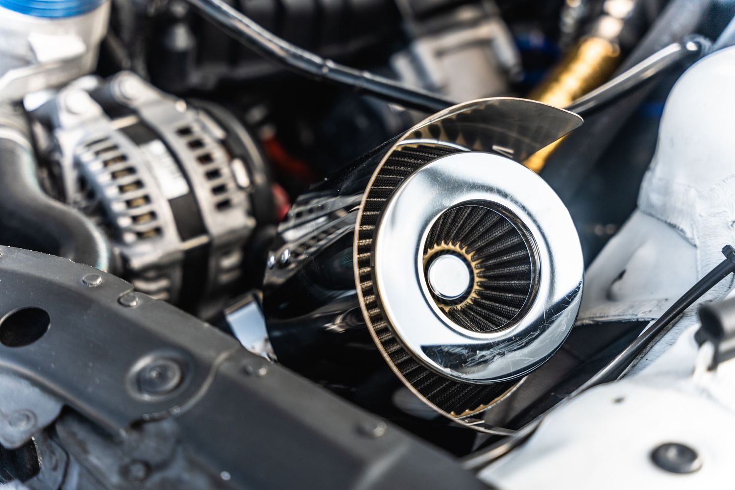 Close-up of turbocharger and alternator in engine bay.