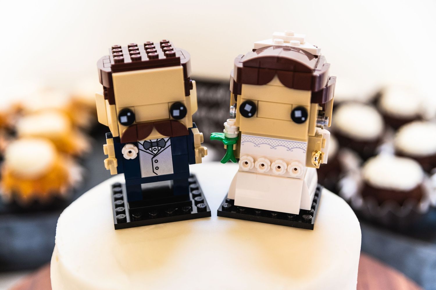 Close-up of LEGO-style bride and groom wedding cake toppers.