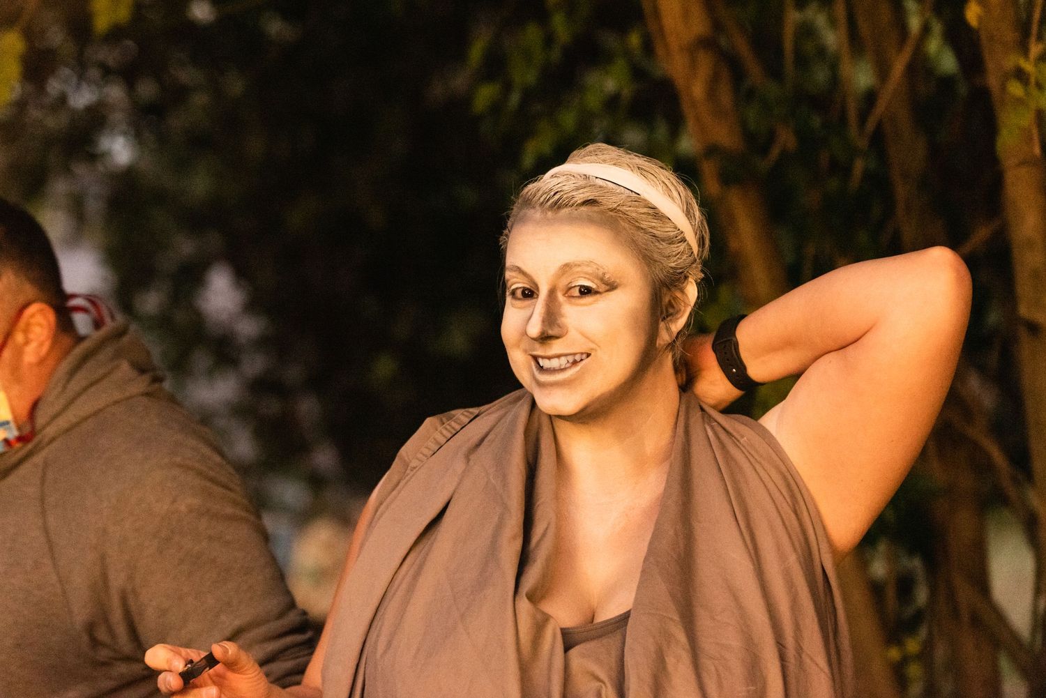 A performer in beige costume poses during an artistic performance.