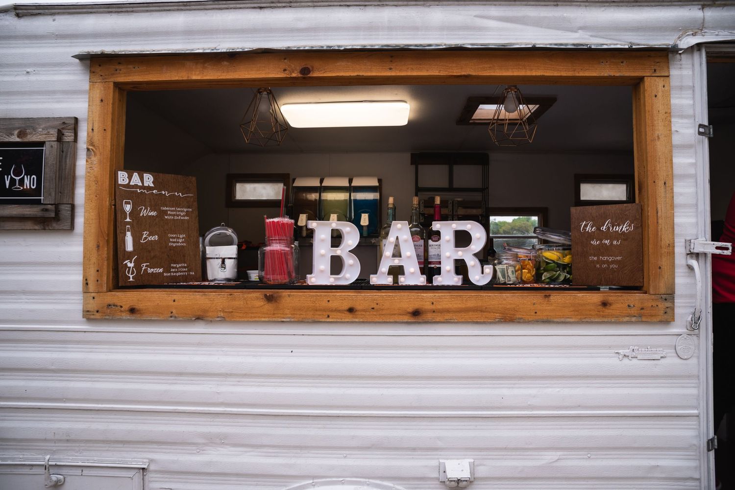 A rustic wooden bar window display with vintage decor and BAR lettering.