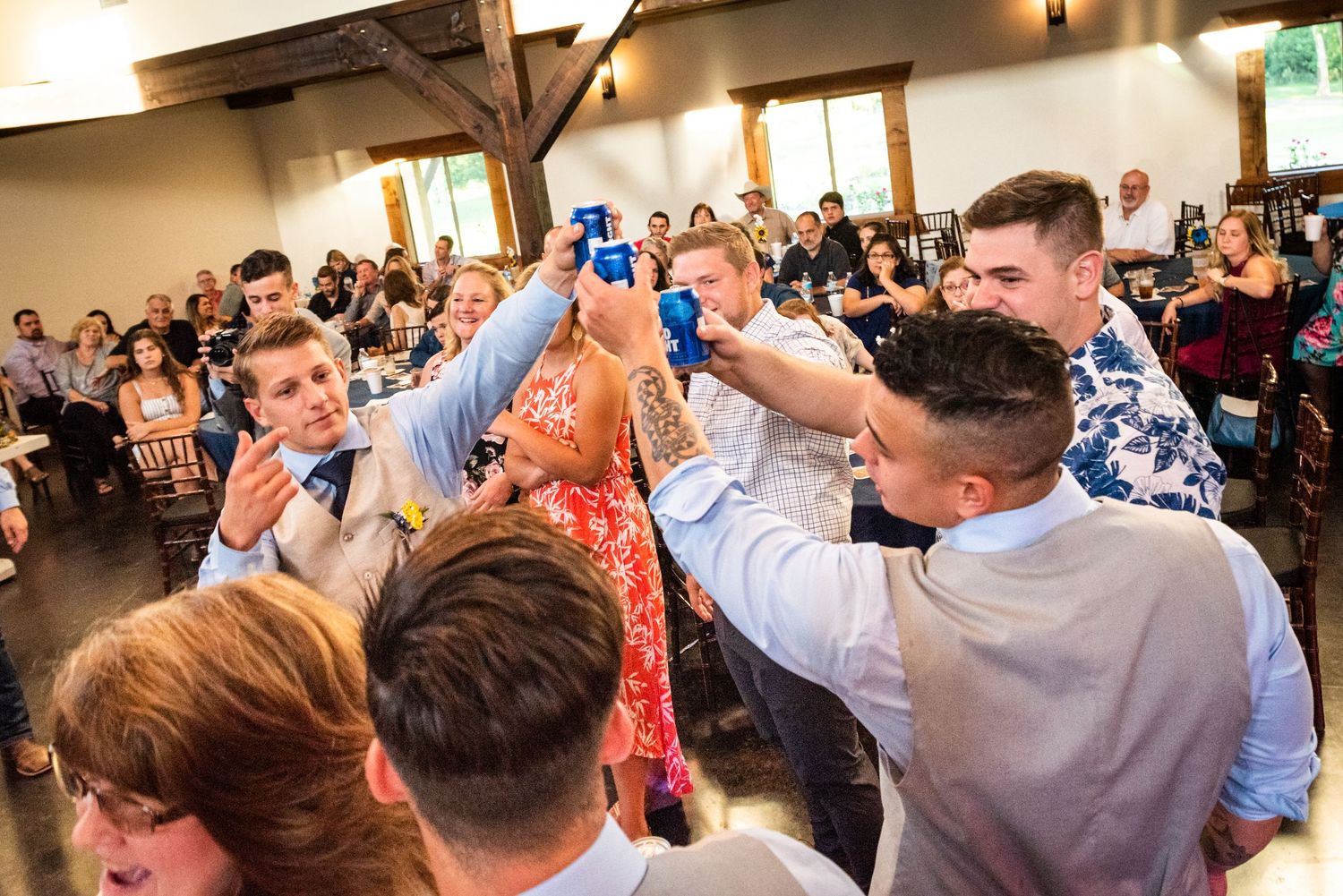 Wedding guests raise their hands in celebration during an energetic dance floor moment.