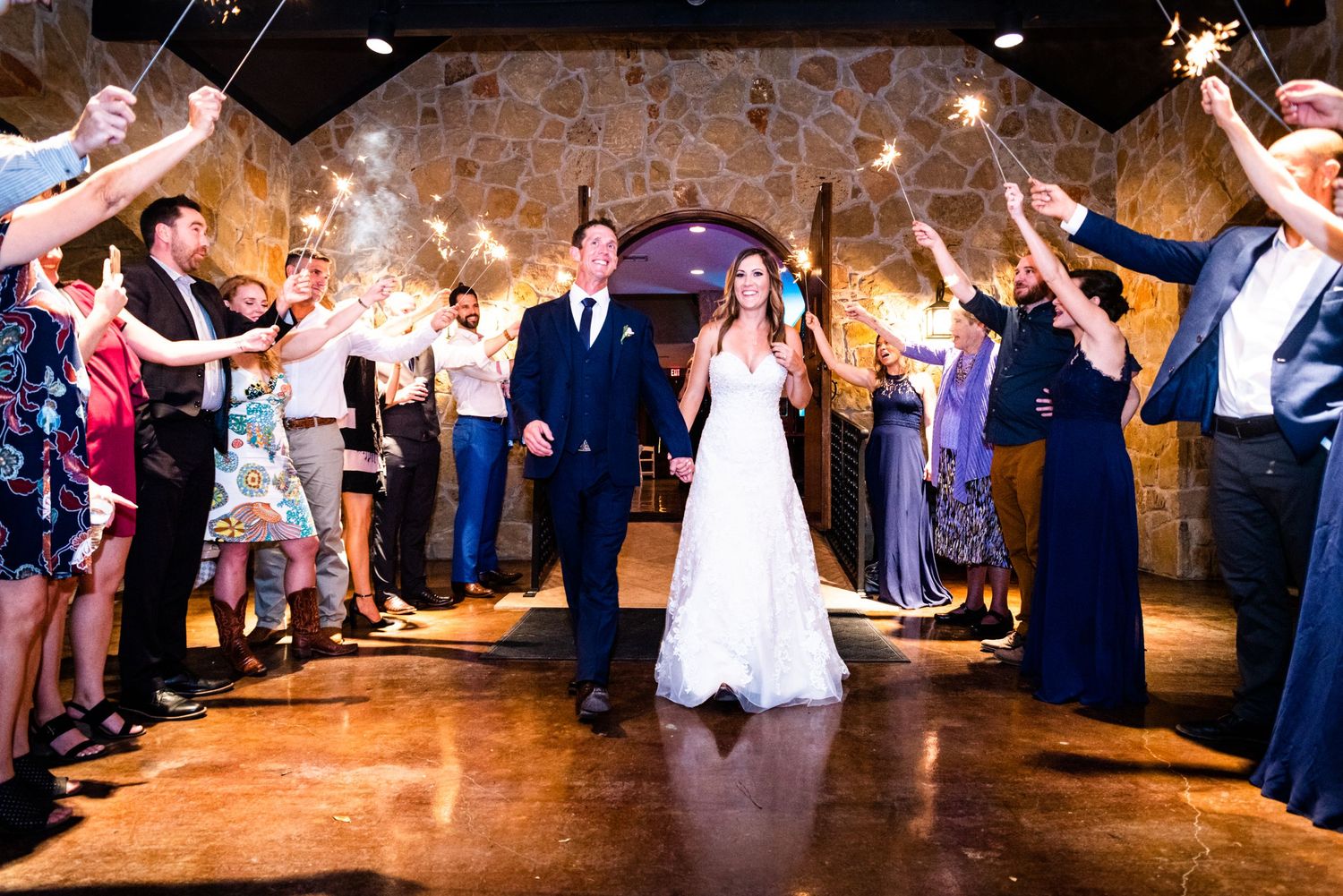 Guests form a sparkler-lit pathway while the newlyweds walk through during their wedding exit.