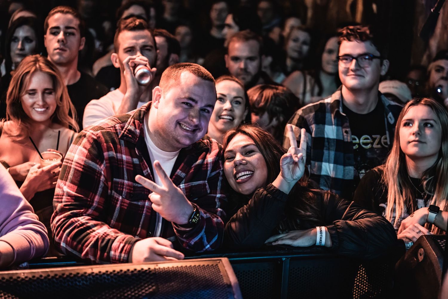Concert crowd enjoying live music performance with enthusiastic expressions.