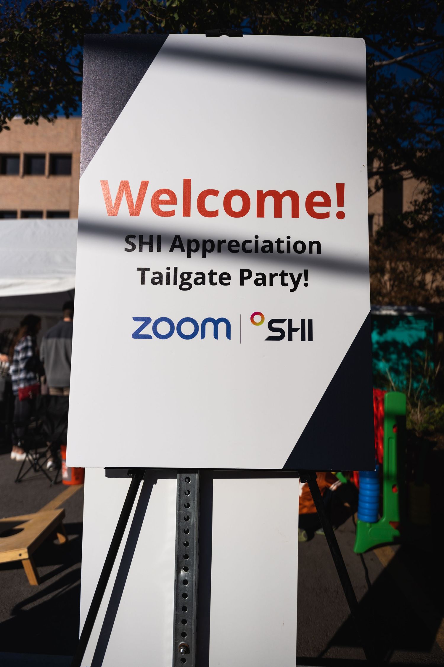 Welcome sign for SHI Appreciation Tailgate Party with Zoom logo displayed on white board.