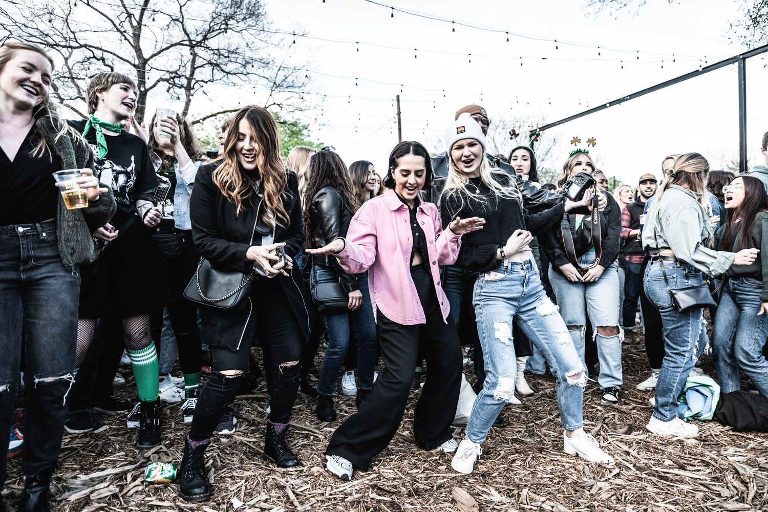 Festival crowd dancing and enjoying music in outdoor venue.