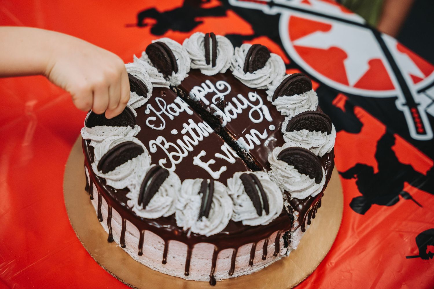 Close up of chocolate drip cake with Oreo decorations and birthday message.