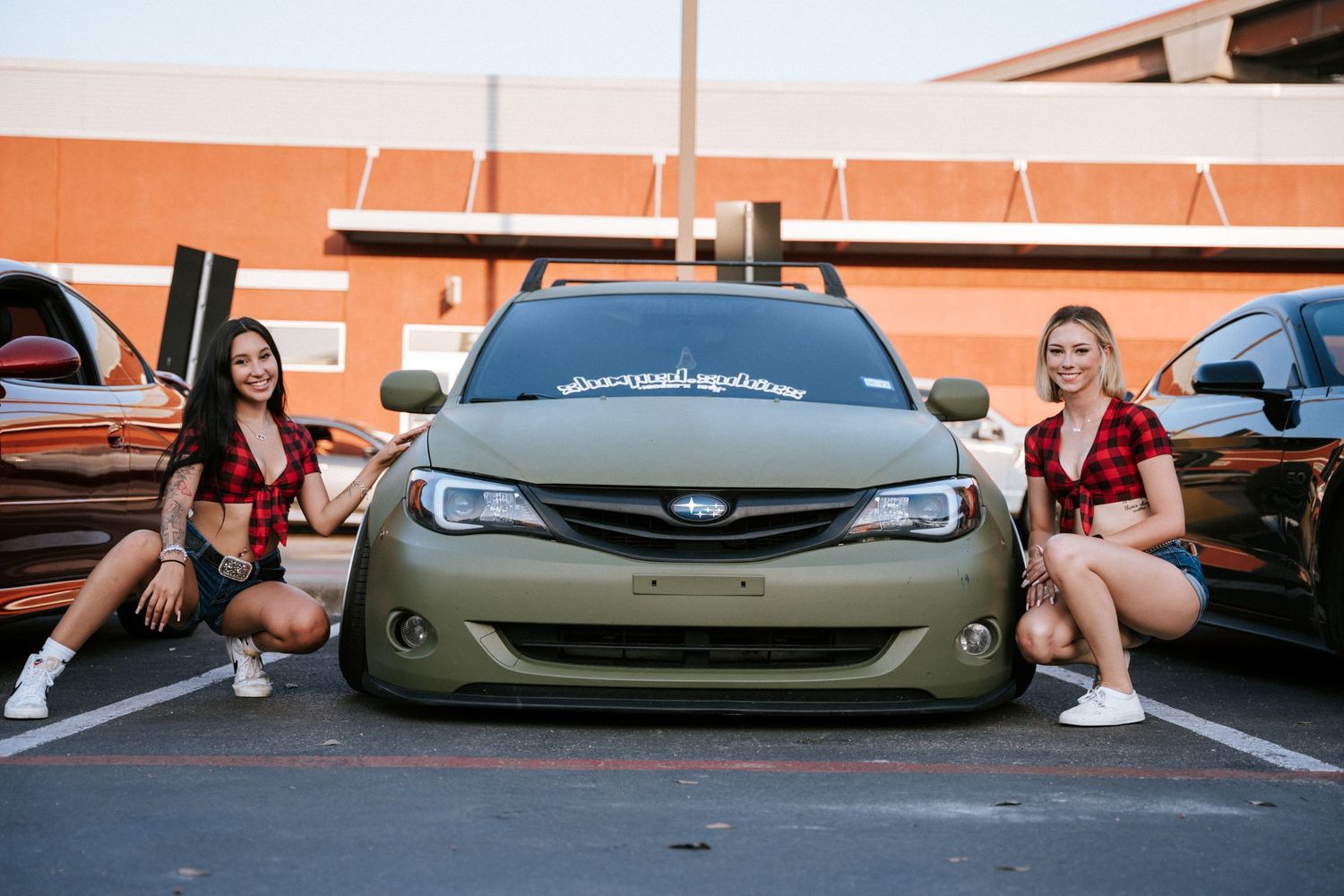 A customized olive green Subaru with lowered suspension showcased at a car meet.