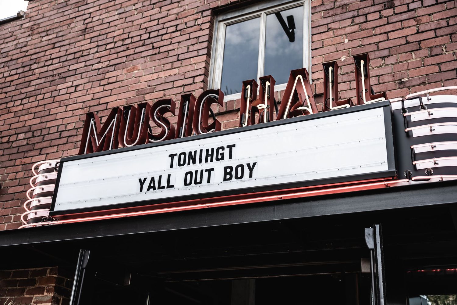 Classic music hall marquee on brick building displaying 'Tonight Yall Out Boy' in red lettering.