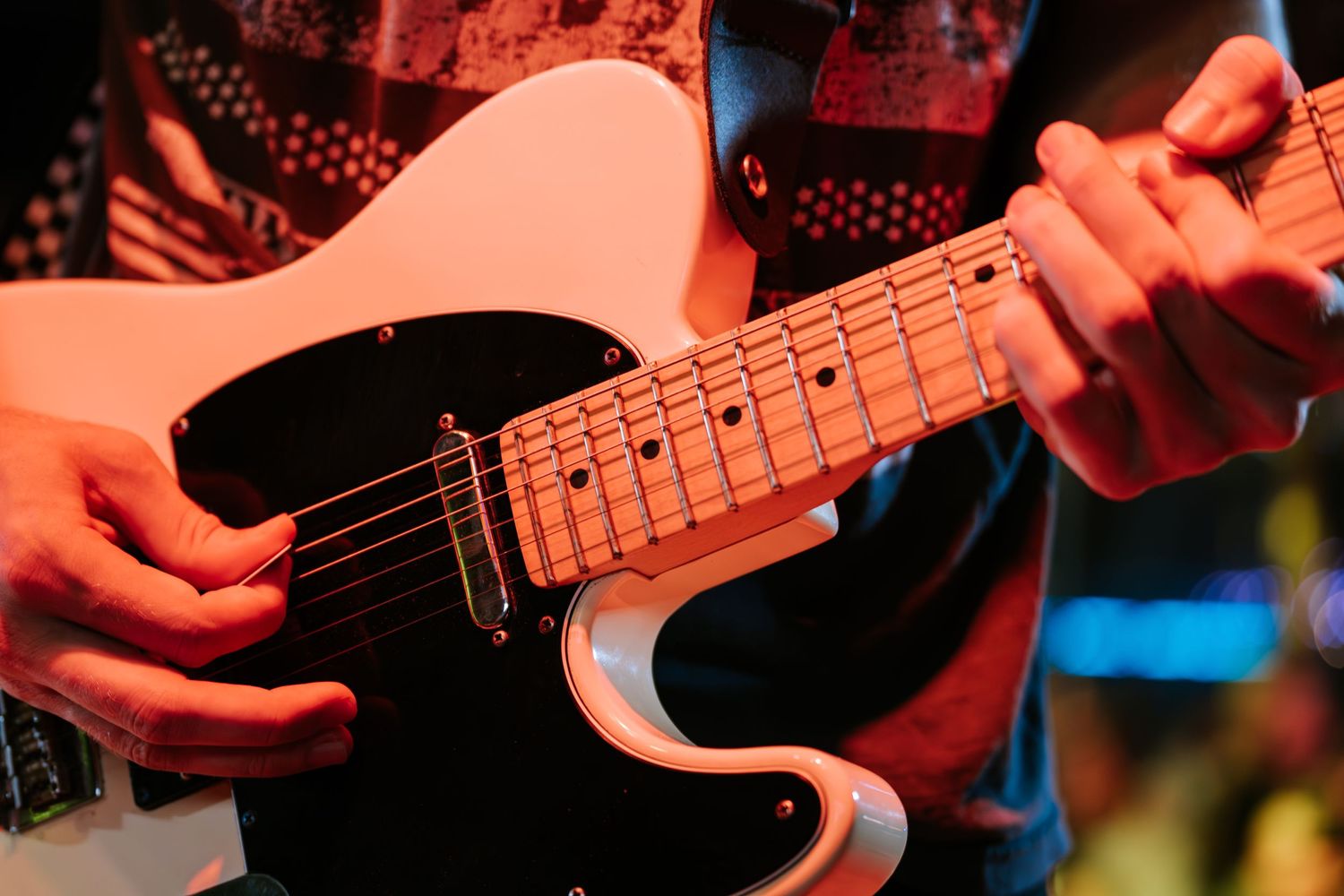 Close-up shot of hands playing an electric bass guitar during a live performance.