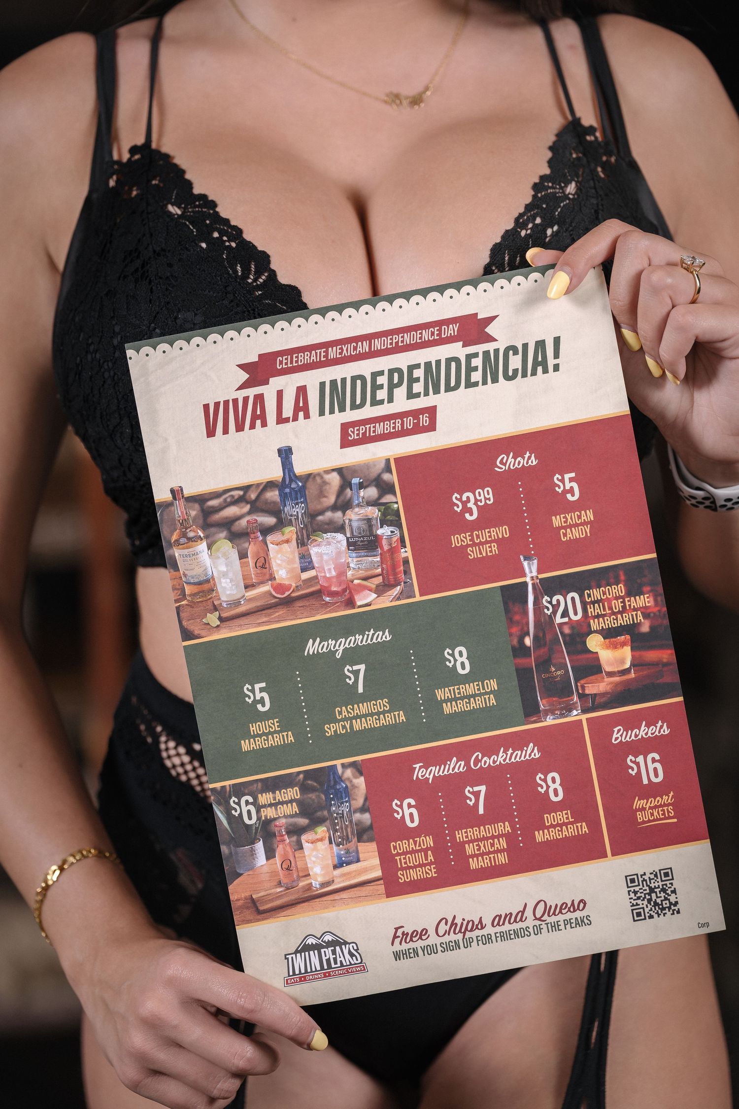Promotional drink menu for 'Viva la Independencia' showing various cocktail specials and prices against a black lace background.