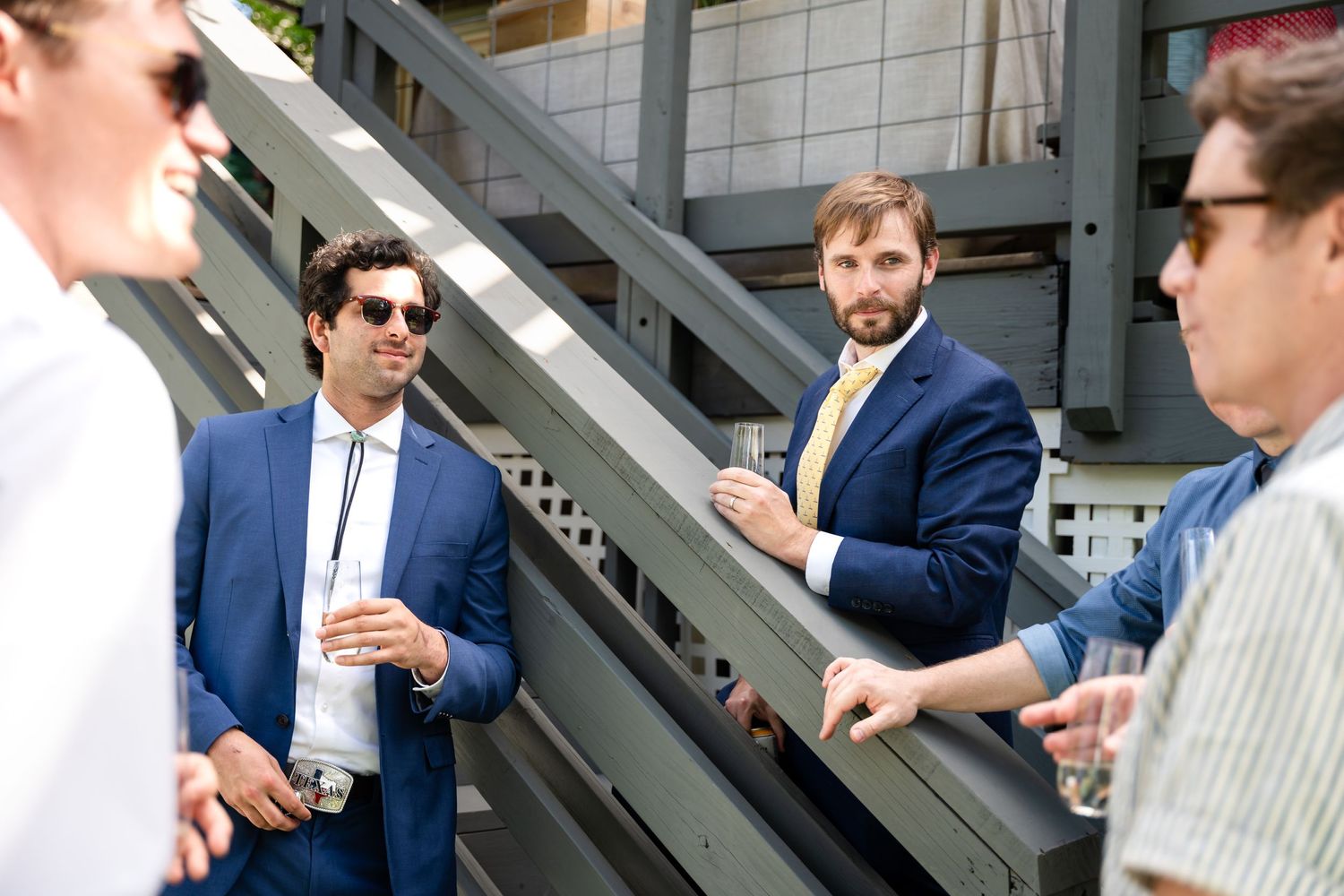 Well-dressed guests socializing on outdoor stairs during a celebration.
