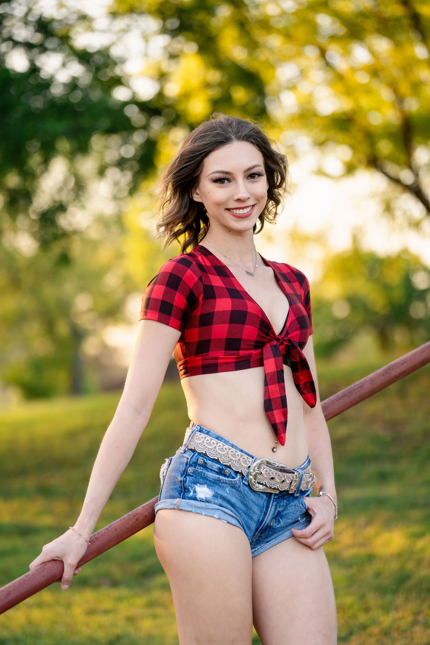 Red buffalo plaid crop top and denim shorts photographed in golden hour lighting outdoors.