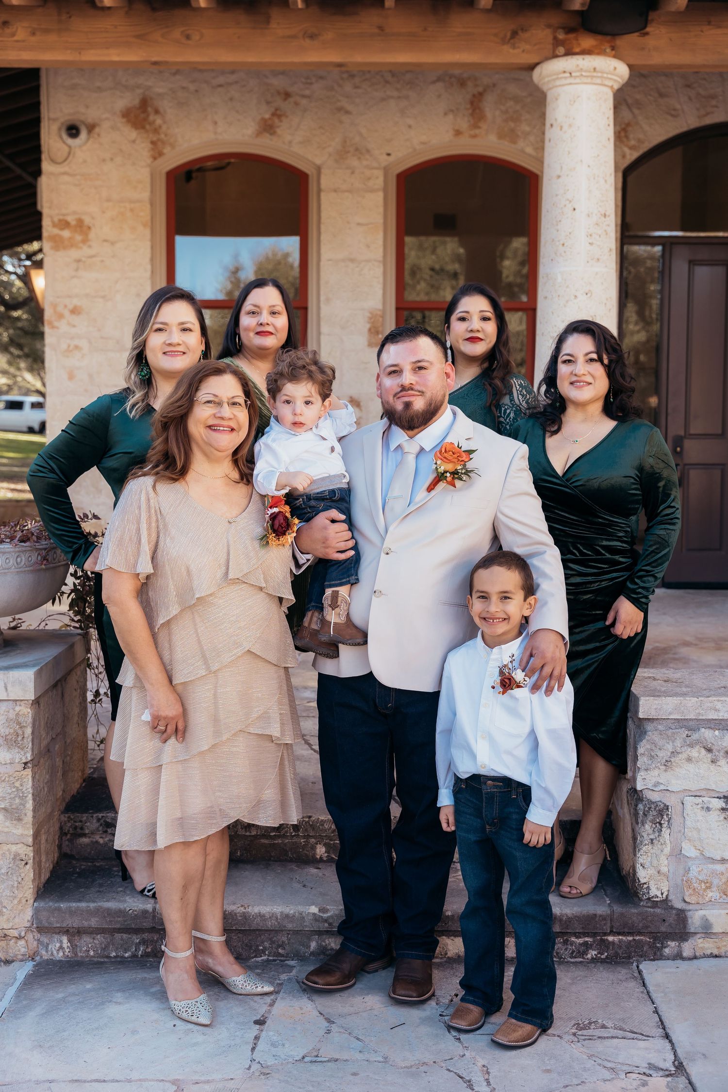 Family group photo outdoors at stone venue with columns on steps.
