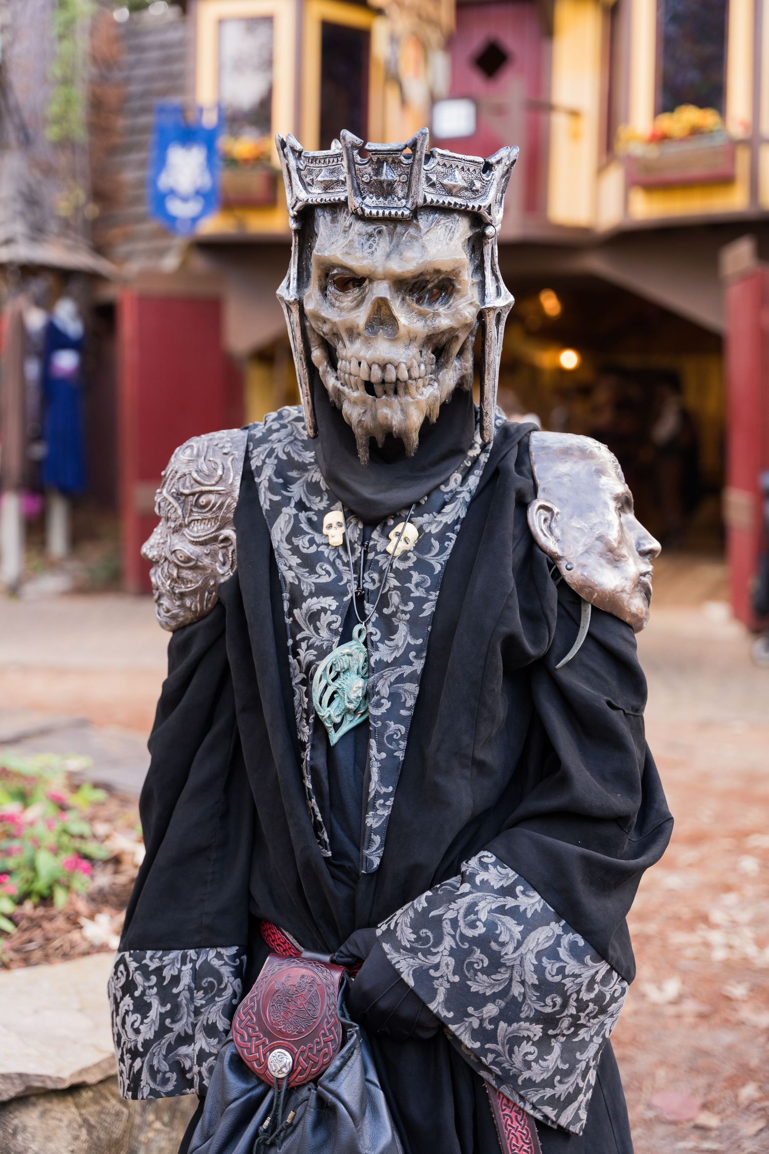 Gothic skeleton costume with silver crown and black robe at renaissance faire.