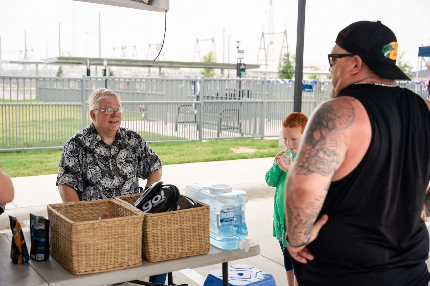 Event staff interacting at an outdoor booth with baskets and supplies.