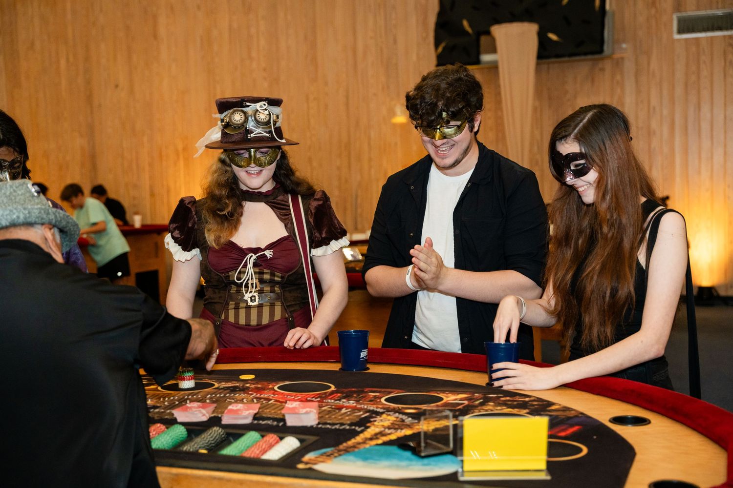 Casino players in masquerade masks gathered around a gaming table.