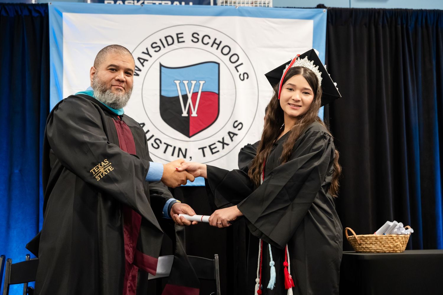 Graduate shakes hands with administrator at Wayside Schools Austin Texas graduation ceremony.