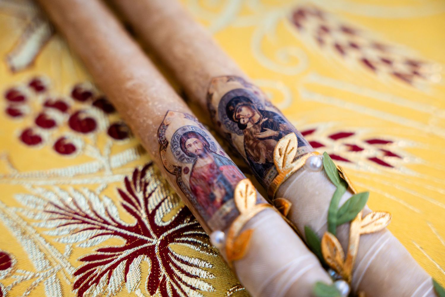 Close-up view of traditional mehndi henna design on hands with decorative bangles against yellow fabric background.