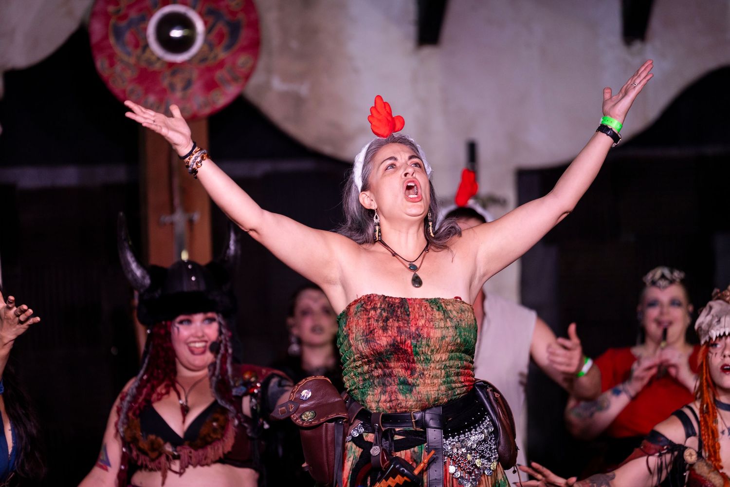 Concert crowd raises their arms in excitement during a live music performance at a nightclub venue.