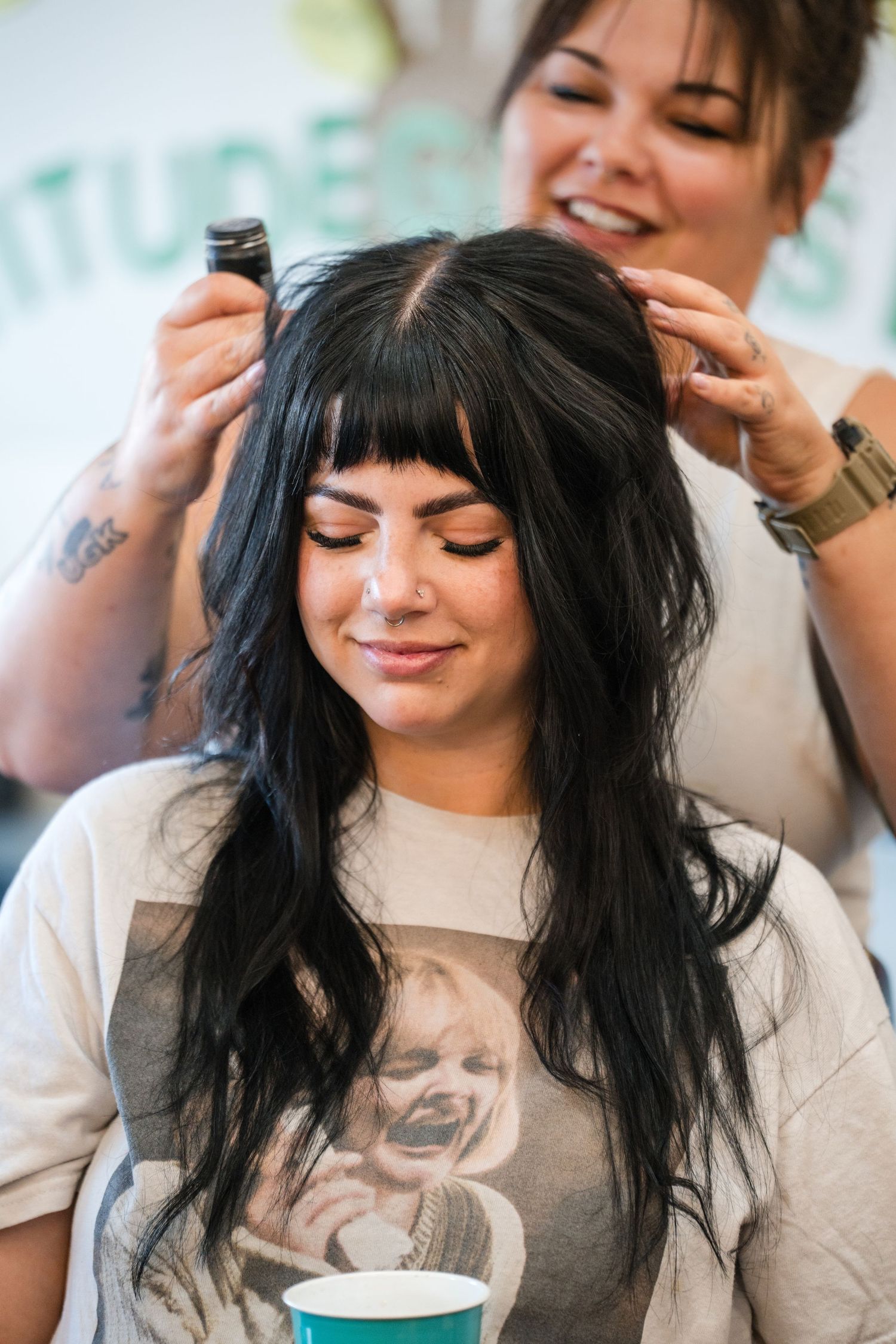 Three candid photos showing someone with long dark hair and bangs getting their hair styled in a salon setting.