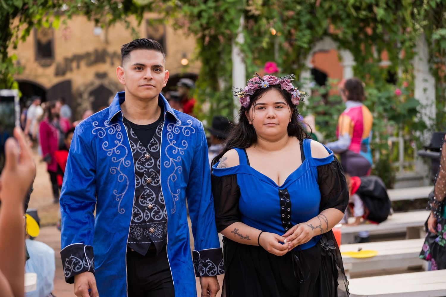 A group of people wearing coordinated royal blue and black traditional outfits at an outdoor gathering.