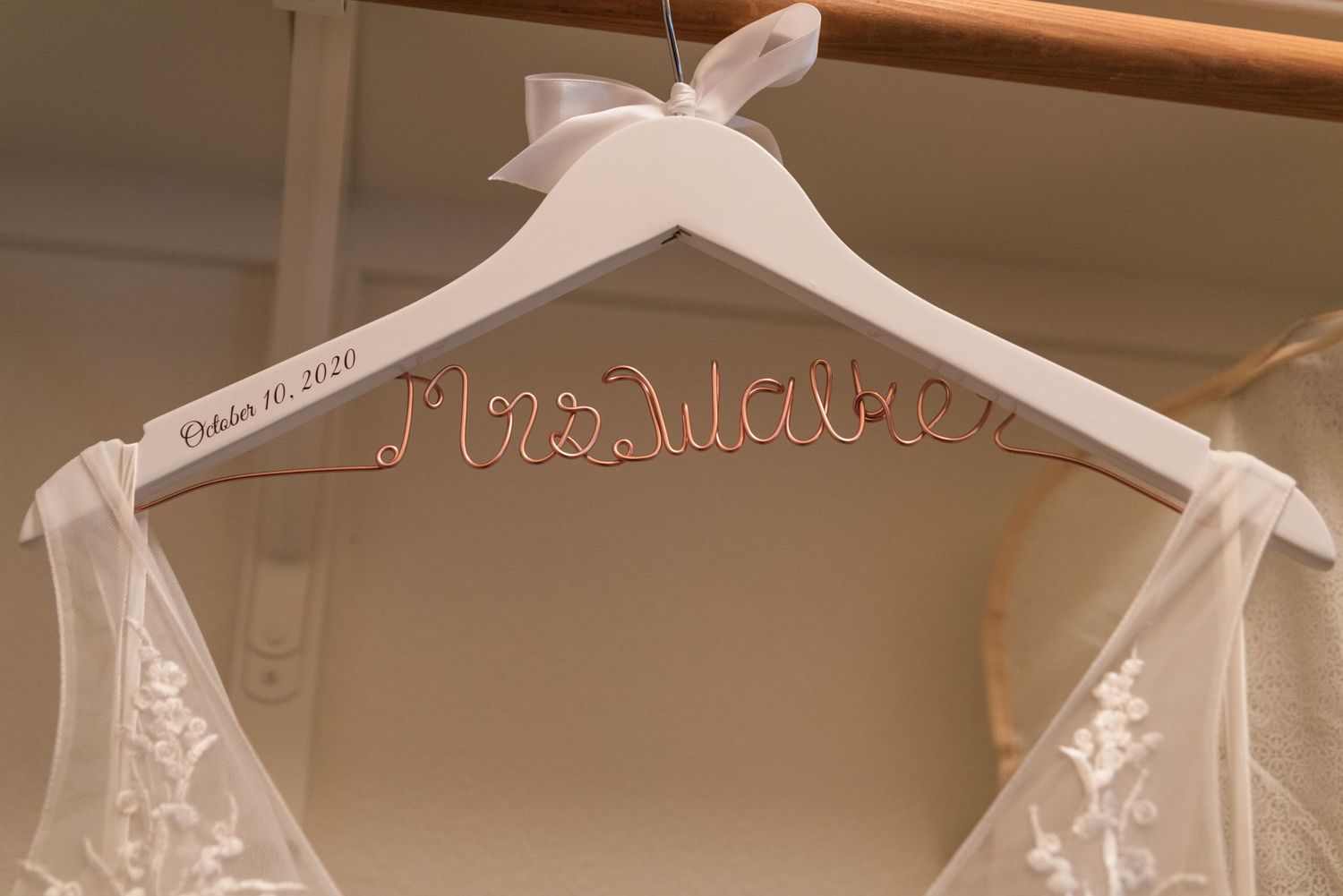 White wedding dress hanger with Mrs. inscription in rose gold wire.