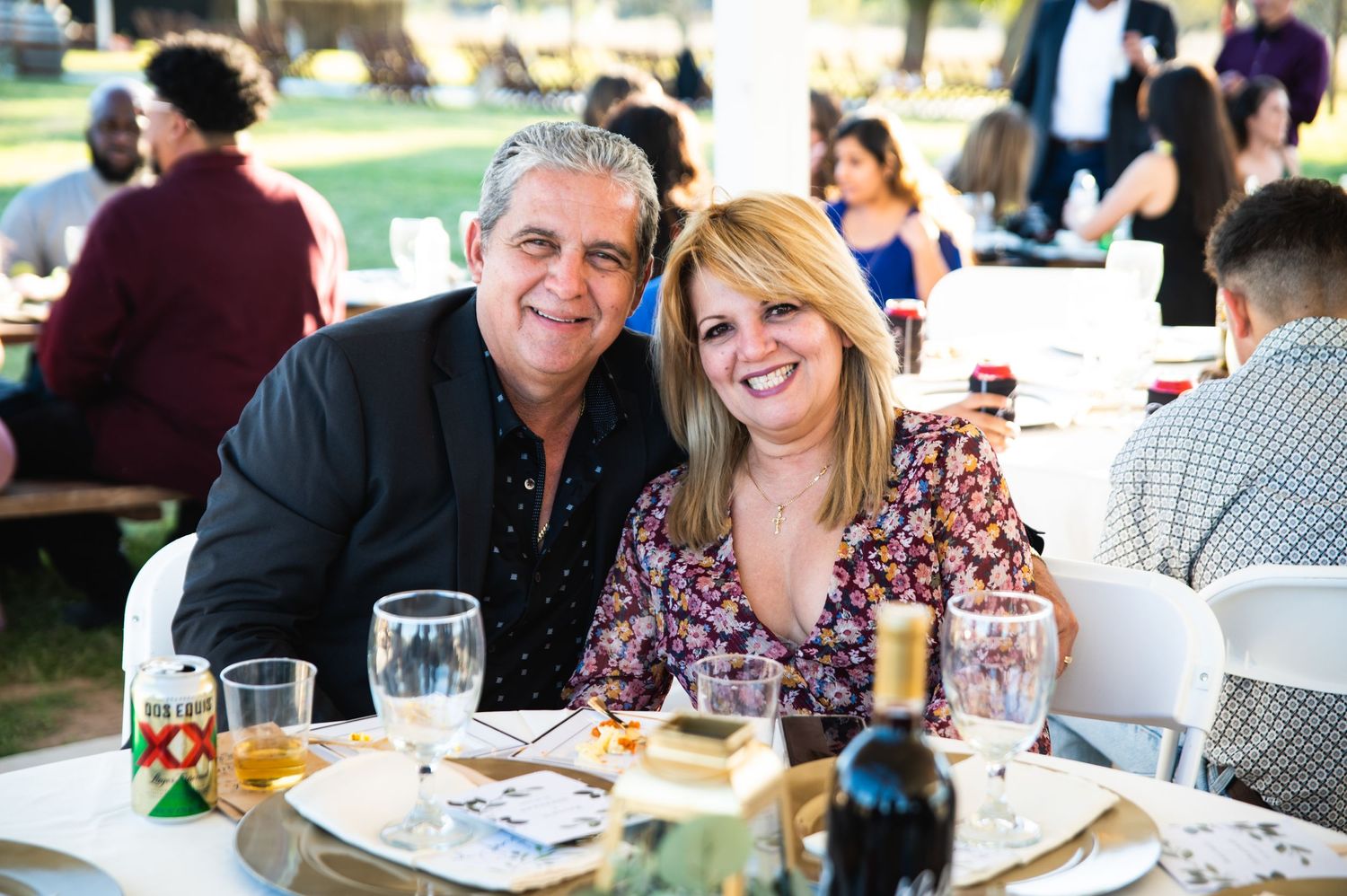 Guests enjoying reception dinner at outdoor wedding celebration.