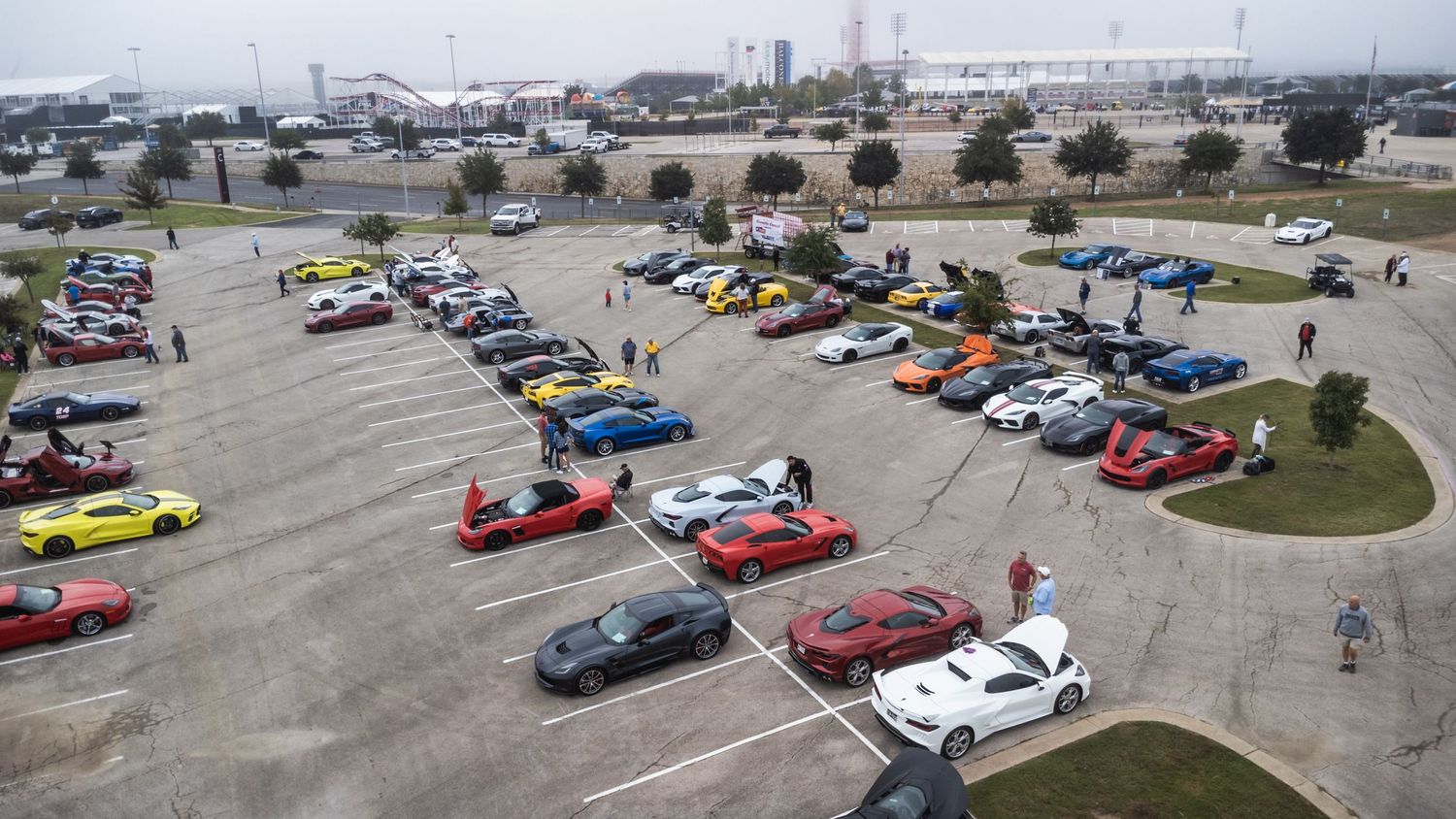 Aerial view of colorful cars arranged in rows at outdoor car show meetup.