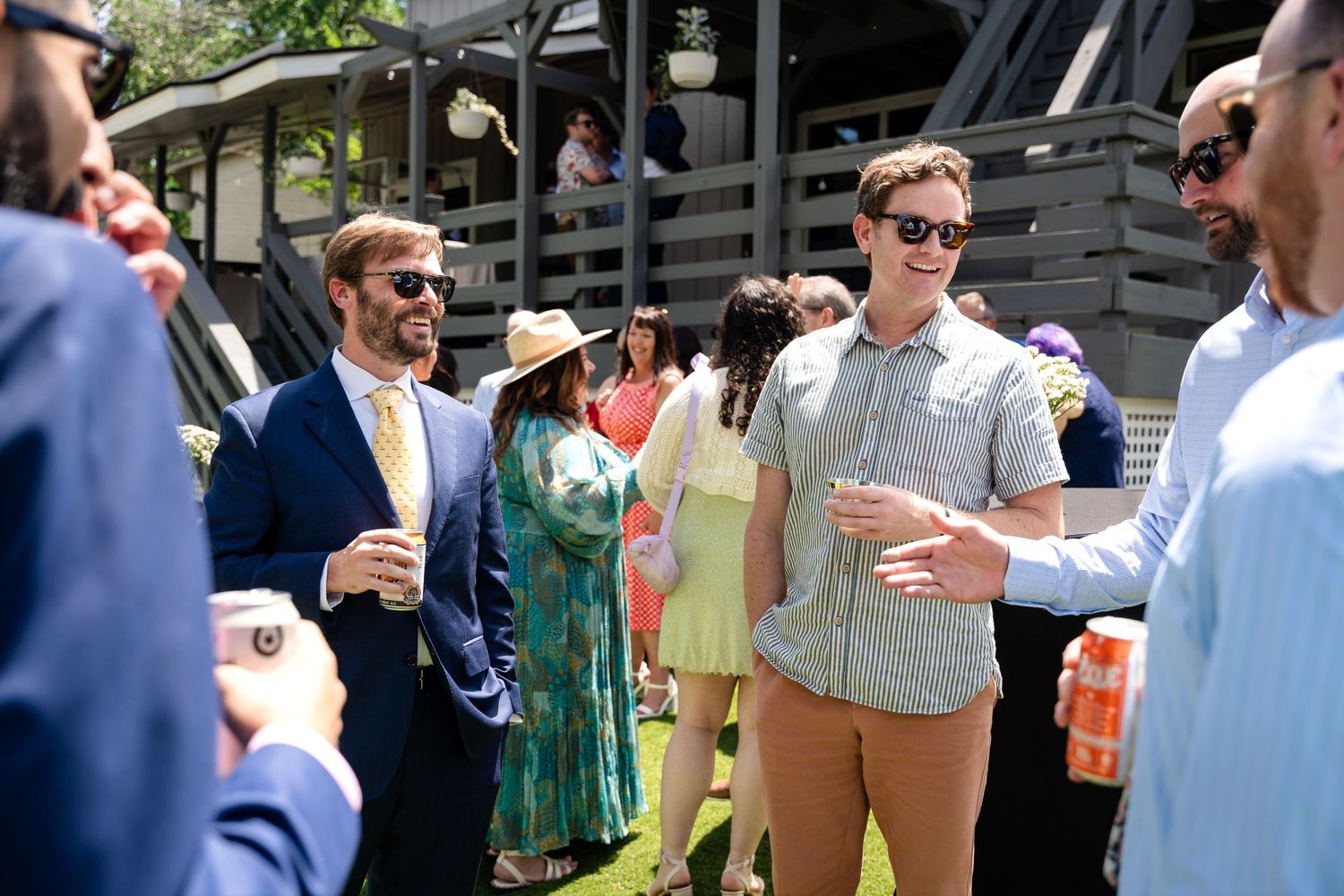 Outdoor wedding guests mingling and socializing at casual daytime reception.