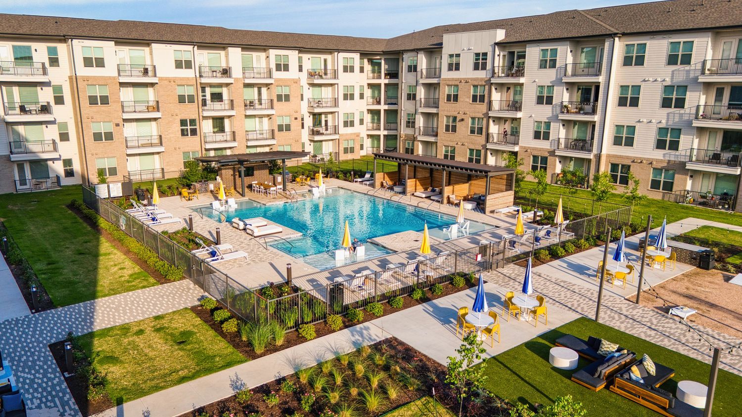 Luxury apartment complex with central courtyard pool and surrounding residential buildings.