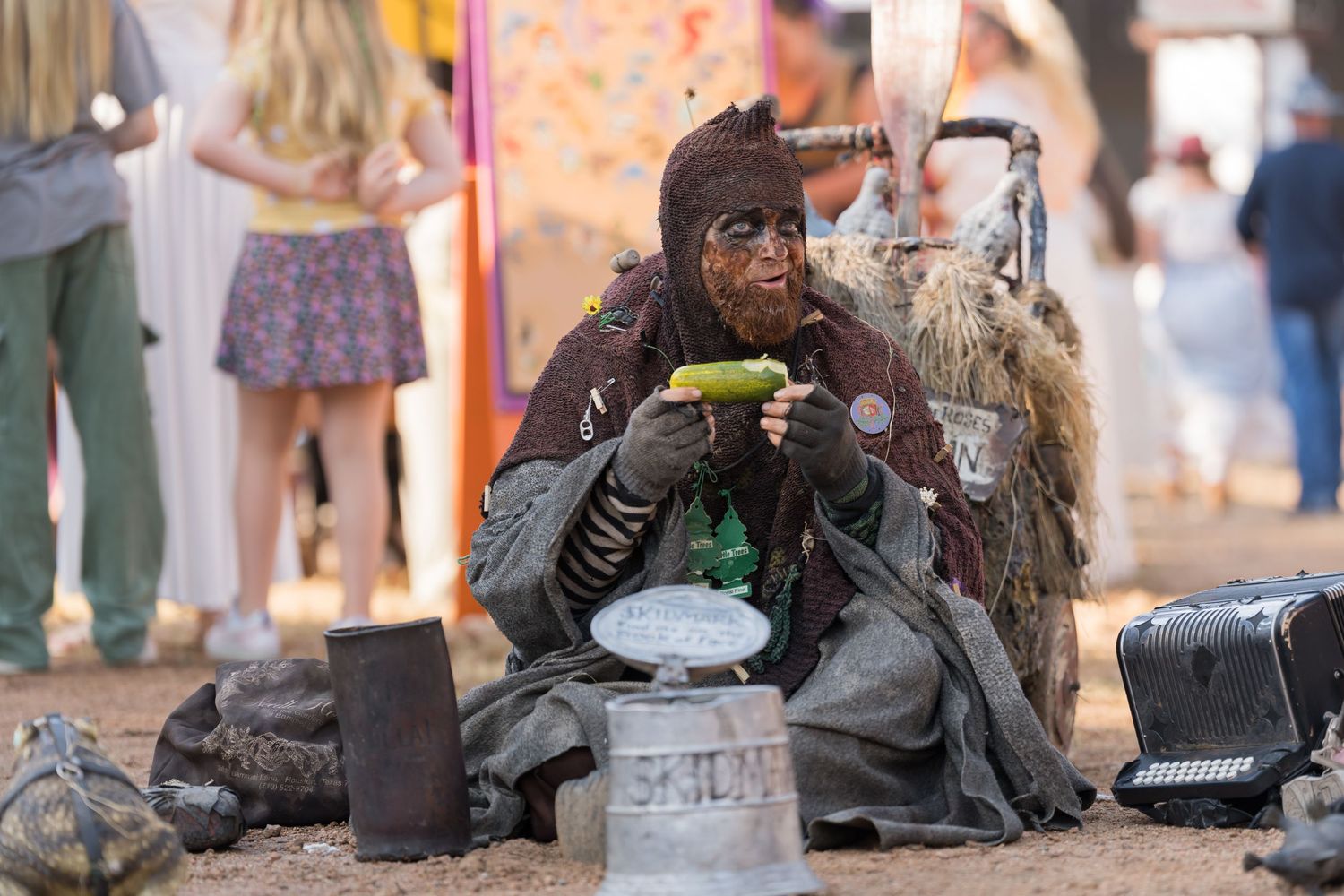 Festival performer in costume taking a break with a hot beverage.